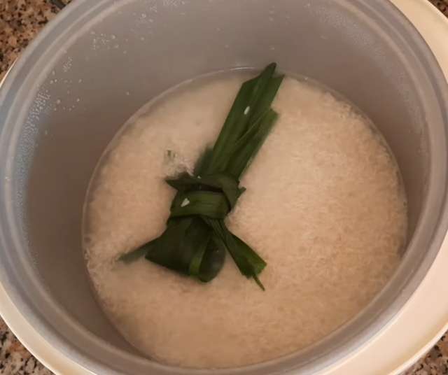 Đun nước sôi cùng với lá dứa, sau đó cho gạo vào nồi