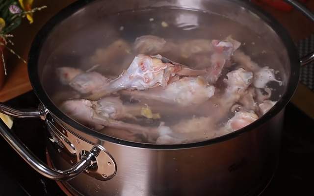Chần xương gà với nước sôi để loại bỏ mùi hôi và tạp chất trong xương gà